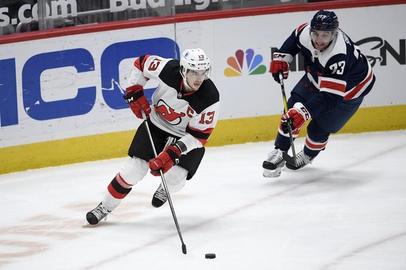 New Jersey Devils center Nico Hischier (13) skates with the puck against Washington Capitals left wing Conor Sheary (73) during the first period of an NHL hockey game, Sunday, Feb. 21, 2021, in Washin ...