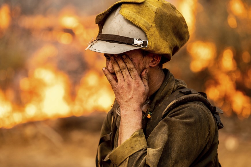 Firefighter Matthew Gerzin of Alaska's Pioneer Peak Interagency Hotshot crew rubs his eye while battling the Mosquito Fire in the Volcanoville community of El Dorado County, Calif., on Friday, Se ...