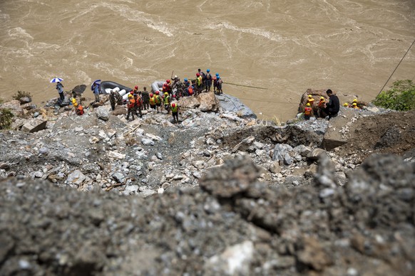 epa11475475 Members of a rescue team conduct a search and rescue operation after two passenger buses were swept away by a landslide, at Trishuli River in Simaltal, Chitwan district, Nepal, 13 July 202 ...