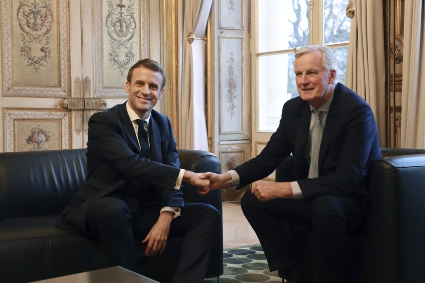 FILE - French President Emmanuel Macron, left, shakes hands with then-European Union chief Brexit negotiator Michel Barnier at the Elysee Palace in Paris, Friday, Jan. 31, 2020. (Ludovic Marin/Pool Ph ...