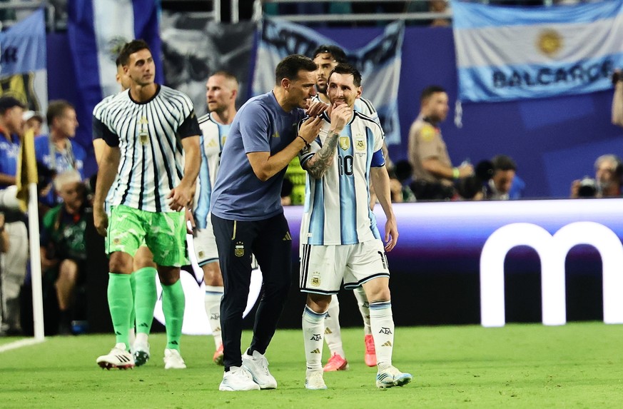 epa13084883 Argentina's head coach Lionel Scaloni talks to team captain Lionel Messi after Argentina scored their third goal during the FIFA World Cup 2026 Round of 32 match Argentina against Cap ...