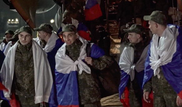 epa12883944 A handout still image taken from handout video provided by the Russian Defence ministry press-service shows Russian prisoners of war (POWs) react following a prisoner swap and arriving Zhu ...