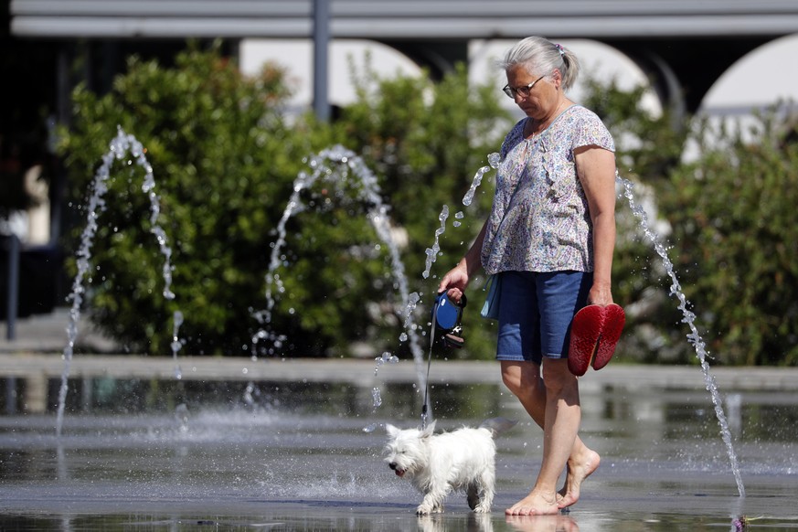 epa10012627 A woman refreshes herself at a public fountain in Montpellier, France, 14 June 2022. The heat continues to hit much of France, a situation that, according to all forecasts, will continue f ...