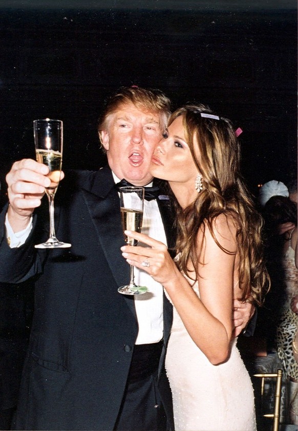 American real estate developer Donald Trump and his girlfriend, model Melania Knauss (later Trump), raise their glasses for a New Year&#039;s toast at the Mar-a-Lago estate, Palm Beach, Florida, Janua ...