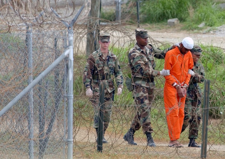 FILE - In this Feb. 6, 2002, file photo a detainee is led by military police to be interrogated by military officials at Camp X-Ray at the U.S. Naval Base at Guantanamo Bay, Cuba. At the time the imag ...