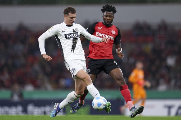 epa11690693 Fisnik Asllani of Elversberg (L) in action against Edmond Tapsoba of Leverkusen (R) during the German DFB Cup soccer match between Bayer Leverkusen and SV Elversberg in Leverkusen, Germany ...