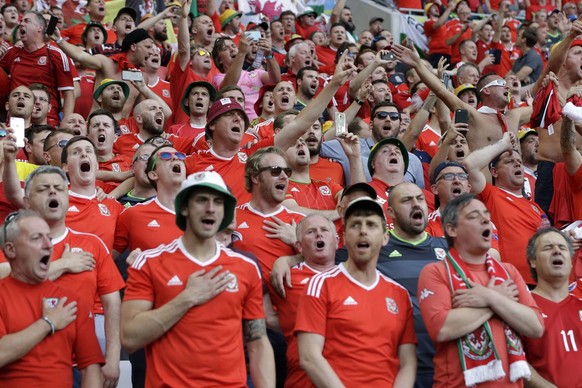 Wales&#039; fans sing their national anthem during the Euro 2016 semifinal soccer match between Portugal and Wales, at the Grand Stade in Decines-­Charpieu, near Lyon, France, Wednesday, July 6, 2016. ...