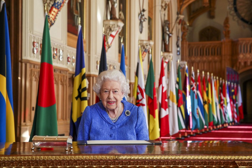 In this photo made available Sunday March 7, 2021, Britain&#039;s Queen Elizabeth II poses for a photo while signing her annual Commonwealth Day Message inside St George&#039;s Hall at Windsor Castle, ...