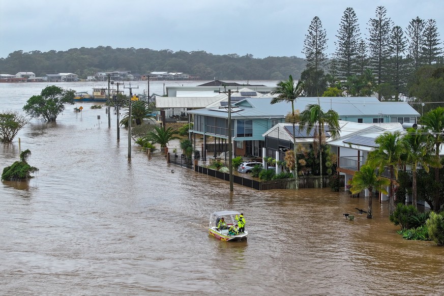 epa12124570 An aerial photo shows NSW Fire Rescue personnel assisting an elderly resident during flooding in Port Macquarie, New South Wales, Australia, 22 May 2025. A slow-moving trough is dumping ra ...