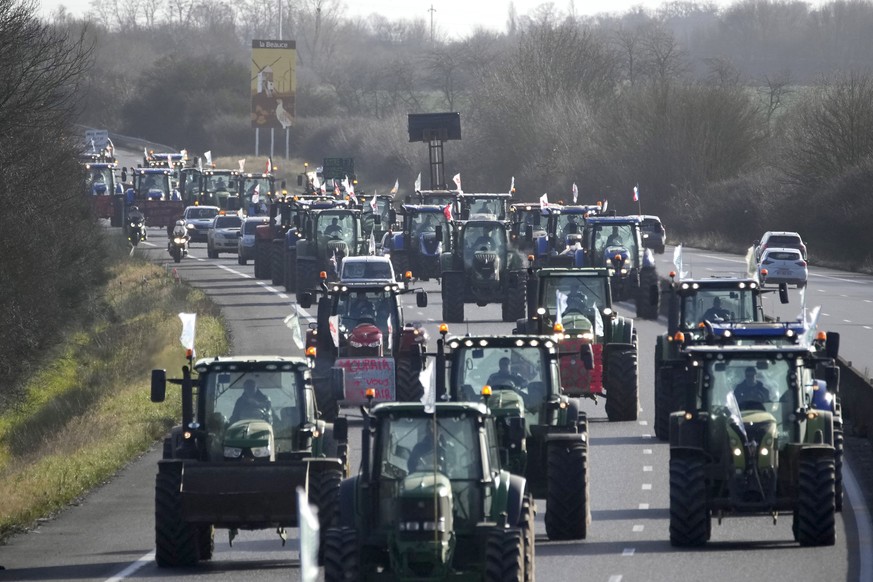 Farmers drive their tractors on their way to a blockade on a highway, Friday, Jan. 26, 2024 near Saint-Arnoult, south of Paris. Protesting farmers shut down long stretches of some of France&#039;s maj ...