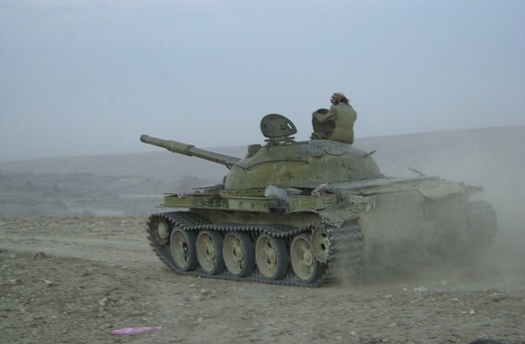 TRB06 - 20011218 - TORA BORA, AFGHANISTAN : An old Russian T-55 tank of the Afghan anti-Taliban forces pulls back from its position in Tora Bora on Tuesday, 18 December 2001, as mujahedin commanders d ...