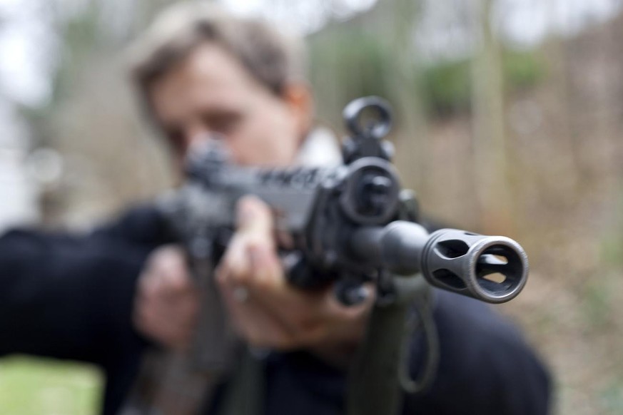 [posed picture] A man poses with an assault rifle 90 of the Swiss Army, a model SIG 550 by manufacturer Swiss Arms AG, pictured on January 6, 2010, in Zurich, Switzerland. (KEYSTONE/Martin Ruetschi)

 ...