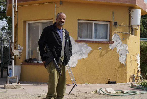 Doron Stamker garde l'entrée du kibboutz de Nir Yitzhak avec son fusil d'assaut.