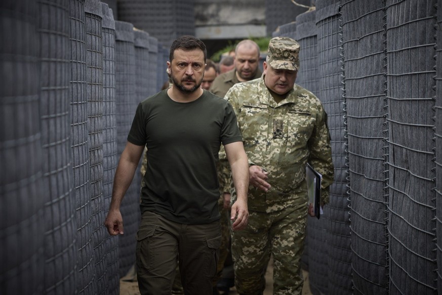 epa11509032 A handout made available by the Presidential Press Service shows Ukrainian President Volodymyr Zelensky (L) inspecting the construction of fortifications at an undisclosed location, during ...