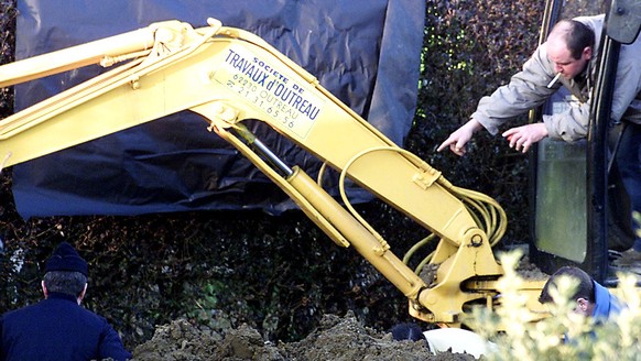 Police officers and forensic experts dig in a garden at Outreau near Boulogne, northern France, Friday, Jan. 11, 2002, looking for the body of a young girl that was allegedly buried there in 1999 afte ...