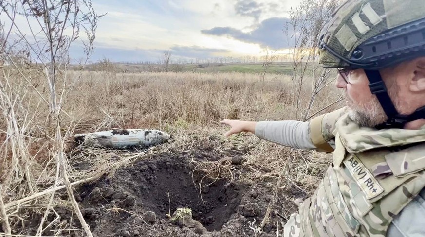 Notre reporter pointe du doigt les vestiges d'une bombe planante qui n'a pas explosé. Les ailes ont été arrachées lors de l'impact.