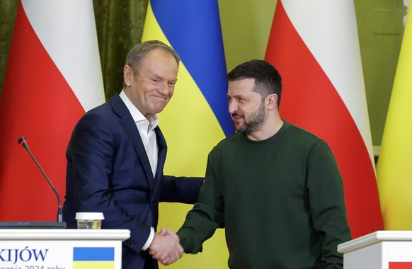 epa11096346 Ukrainian President Volodymyr Zelensky (R) and Polish Prime Minister Donald Tusk (L) shake hands during a statement to the media after their meeting in Kyiv, Ukraine, 22 January 2024. Tusk ...