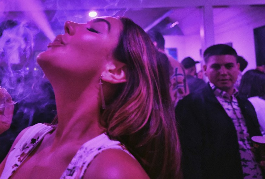 FILE - A guest takes a puff from a marijuana cigarette at the Sensi Magazine party celebrating the 420 holiday in the Bel Air section of Los Angeles on April 20, 2019. California lawmakers, on Tuesday ...
