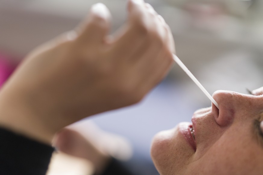 Eine Frau macht einen Coronavirus Antigen-Selbsttest mit Nasenabstrich bei sich zu Hause, am Mittwoch 7. April 2021 in Zuerich. (KEYSTONE/Gaetan Bally)