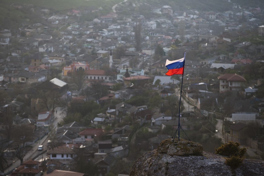 FILE - In this March 28, 2014 file photo, a Russian national flag flies on a hilltop near the city of Bakhchysarai, Crimea. The Group of Seven major industrialized countries on Thursday March 18, 2021 ...