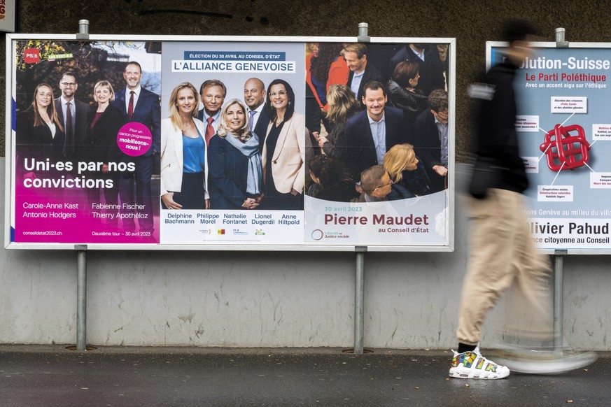 Une personne passe devant les affiches electorales du deuxieme tour de l&#039;election du Conseil d&#039;Etat, l&#039;affiche du parti Socialiste et les Verts avec les candidats, Carole-Anne Kast, Ant ...