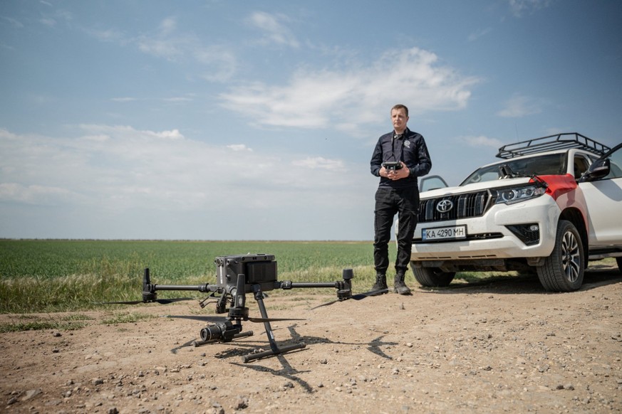 Un employé de HALO Trust lance un drone pour repérer les engins explosifs et transmettre les données aux équipes au sol.