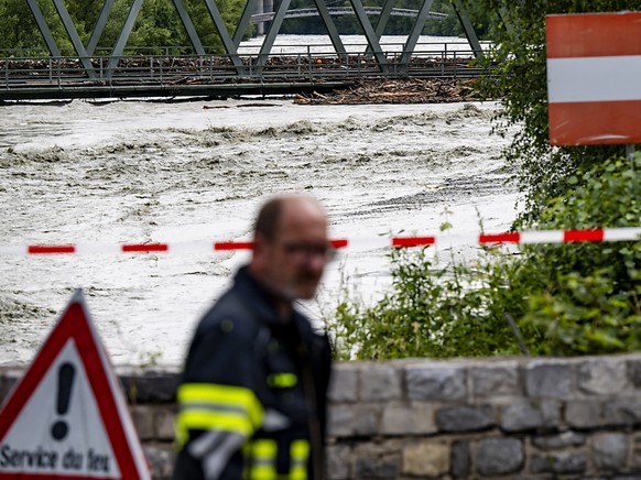 Un pompier surveille le debit du Rhone le samedi entre Sierre et Chippis en Valais.