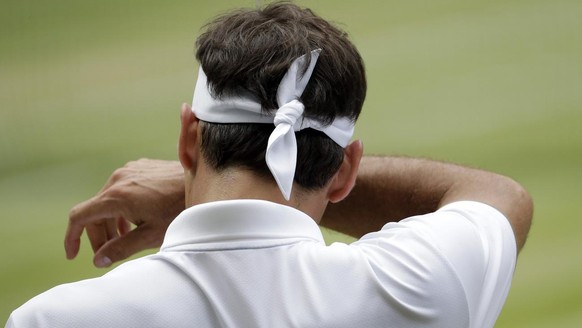 Switzerland's Roger Federer wipes his face during the men's singles final match against Serbia's Novak Djokovic at the Wimbledon Tennis Championships in London, Sunday, July 14, 2019. ( ...