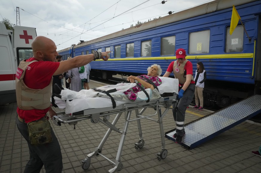 Paramedics push an elderly woman on a gurney into a specially equipped medical train run by Doctors Without Borders to evacuate patients and wounded from the war hit area, in Pokrovsk, Donetsk region, ...