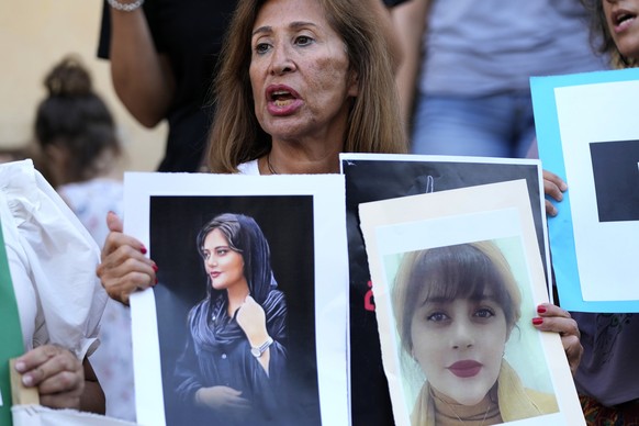 An activist holds portraits of Iranian Mahsa Amini, during a protest against her death in Iran, in Beirut, Lebanon, Sunday, Oct. 2, 2022. Iran&#039;s parliamentary speaker Mohammad Bagher Qalibaf warn ...