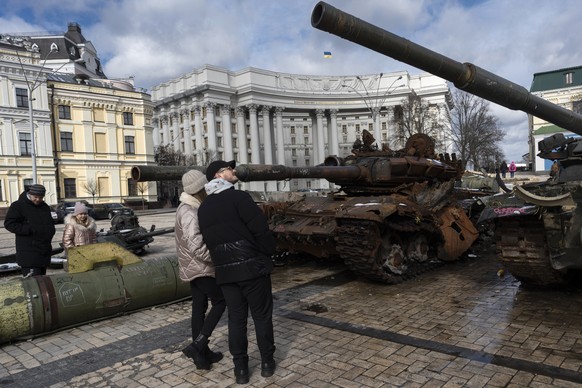 People watch destroyed Russian tanks and armoured vehicles on display near the St. Michael&#039;s Cathedral in downtown Kyiv, Ukraine, Sunday, March 12, 2023. (AP Photo/Andrew Kravchenko)