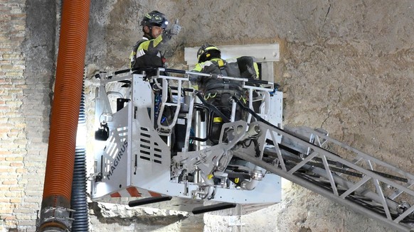 A firefighter gives a thumbs-up as rescuers pull a construction worker from under the debris of a medieval tower that was under renovation near the Roman Forum in Rome, Monday, Nov. 3, 2025, after it  ...
