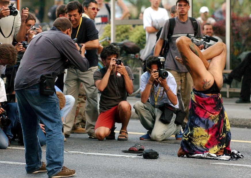 Photographed by medias, an anti-globalisation protester performs in front of Swiss riot police as hundreds of anti-G demonstrators are cordoned off by riot police in a tense standoff, on Geneva's ...