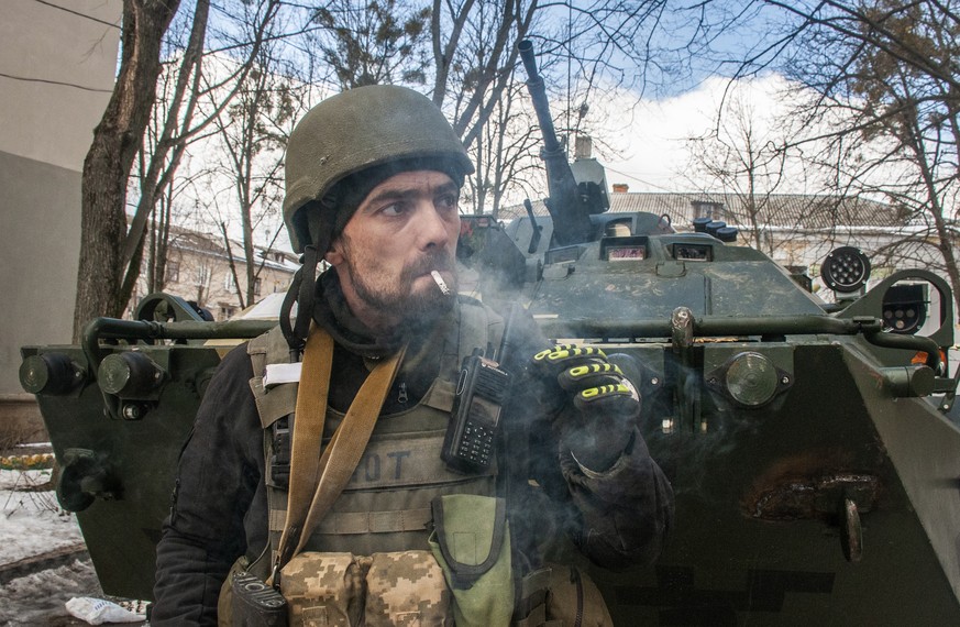 A volunteer of the Ukrainian Territorial Defense Forces smokes in Kharkiv, Ukraine, Wednesday, March 16, 2022. (AP Photo/Andrew Marienko)