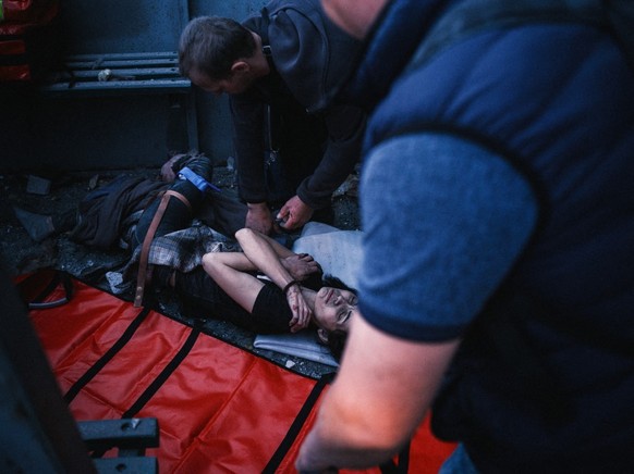 KHARKIV, UKRAINE - APRIL 18: Paramedics tend to the wounded after Russian shelling of a civilian light industry production facility producing creams and perfumes in Kharkiv, capital of Kharkiv Oblast, ...