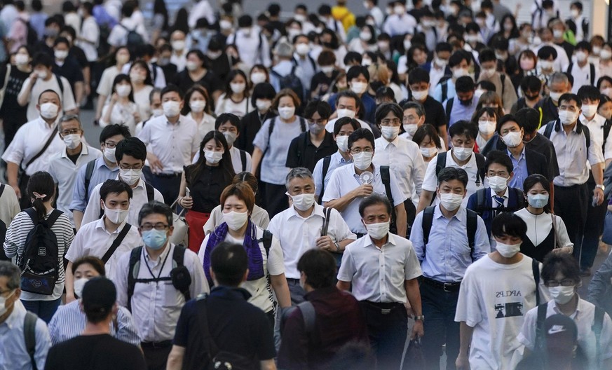 epa10095392 People wearing protective masks walk towards Shinjuku railway stations after their work in Tokyo, Japan, 28 July 2022. Tokyo marked a new record of 40,406 new cases of the COVID-19 per day ...