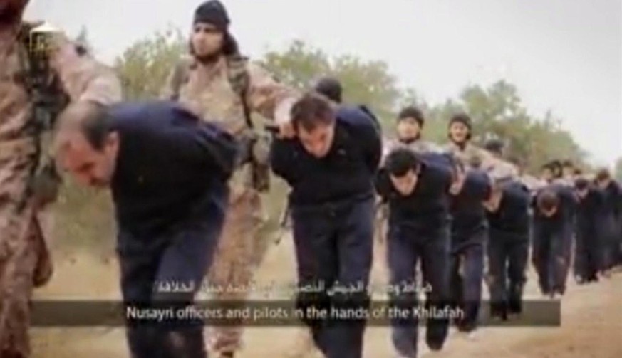 This still image taken from an undated video published on the Internet by the Islamic State group militants and made available, Sunday, Nov. 16, 2014, purports to show extremists marching Syrian soldi ...