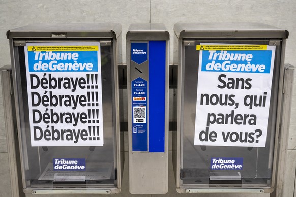 Deux cassettes a journaux avec leurs manchettes sont photographies pendant que les journalistes et des employes de la Tribune de Geneve (TDG) quotidien appartenant au groupe de presse zurichois Tamedi ...