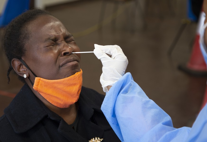 A woman man gets tested for COVID-19 at a site near Johannesburg, Monday, Dec. 13, 2021 a day after South African President Cyril Ramaphosa tested positive receiving for mild COVID-19 symptoms after t ...
