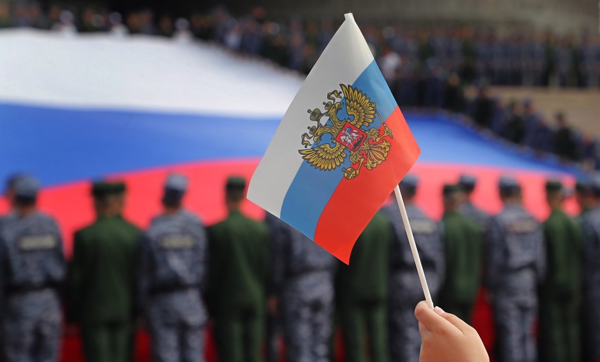 epa10133375 Russian soldiers hold a huge National flag of Russia, at the Poklonnaya hill, marking the Russian National Flag Day in Moscow, Russia, 22 August 2022. The day marks the anniversary of the  ...