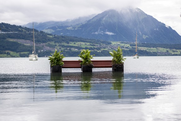 Eine Sitzbank steht im Wasser des Thunersees, am Donnerstag, 14. Juli 2021, in Neuhaus bei Interlaken. Nach den intensiven Regenfaellen der letzten Tagen werden die Ufer zum Teil ueberschwemmt. (KEYST ...