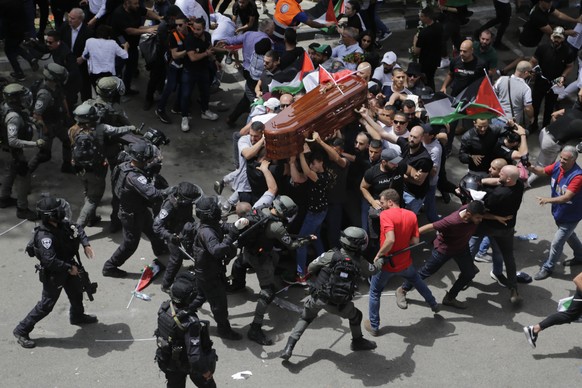 Israeli police confront with mourners as they carry the casket of slain Al Jazeera veteran journalist Shireen Abu Akleh during her funeral in east Jerusalem, Friday, May 13, 2022. Abu Akleh, a Palesti ...