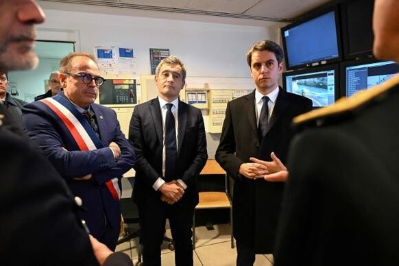 Newly appointed French Prime Minister Gabriel Attal (R) and French Interior Minister Gerald Darmanin (C), flanked by Mayor of Ermont Xavier Haquin (L), meet with police officers as they visit Ermont-E ...