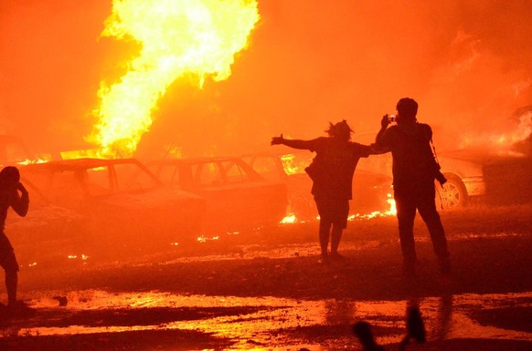 epa09234470 A man photographs vehicles on fire at a parking lot in Popayan Colombia, 28 May 2021. Colombia marks one month of continuous protests against the government and police brutality. EPA/Mario ...