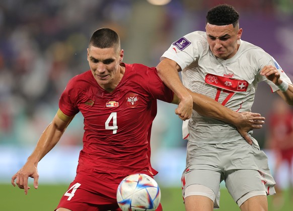 epa10344964 Nikola Milenkovic (L) of Serbia in action against Ruben Vargas of Switzerland during the FIFA World Cup 2022 group G soccer match between Serbia and Switzerland at Stadium 947 in Doha, Qat ...