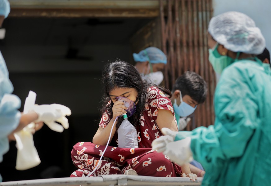 epa09156209 Indian health workers attend to a suspected covid-19 positive patient at the Covid-19 hospital in Kolkata, Eastern India, 24 April 2021. India recorded a massive surge of 332,730 fresh Cov ...
