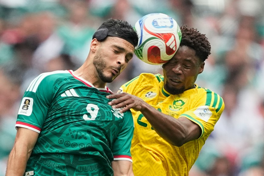 Mexico's Raul Jimenez, left, jumps for the ball with South Africa's Ime Okon during the World Cup Group A soccer match between Mexico and South Africa in Mexico City, Thursday, June 11, 2026 ...