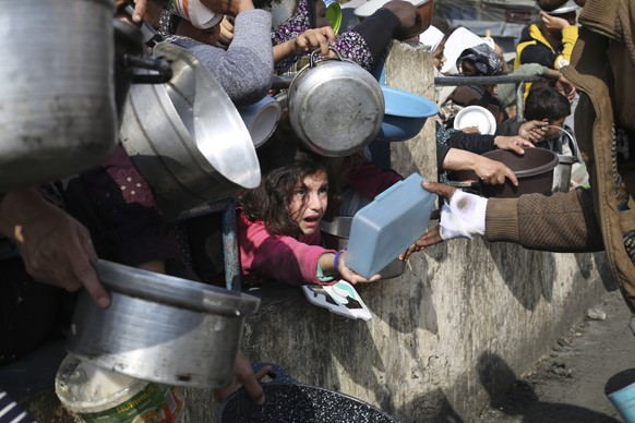 FILE - Palestinians line up for free food during the ongoing Israeli air and ground offensive on the Gaza Strip in Rafah, Jan. 9, 2024. The United Nations said Tuesday, May 21, 2024, it suspended food ...