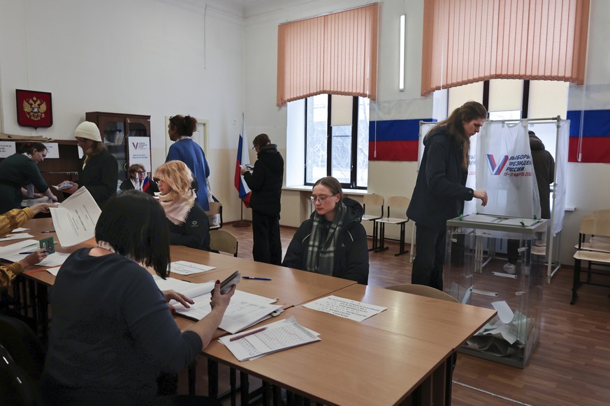 People attend voting during a presidential election in the Pacific port city of Vladivostok, east of Moscow, Russia, Sunday, March 17, 2024. Voters in Russia are heading to the polls for a presidentia ...
