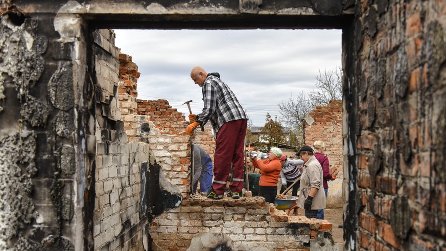 epaselect epa10273113 Volunteers clean the debris of a house, destroyed in combat action in Novoselivka village, Chernihiv region, Ukraine, 29 October 2022. A group of local people from Chernihiv and  ...